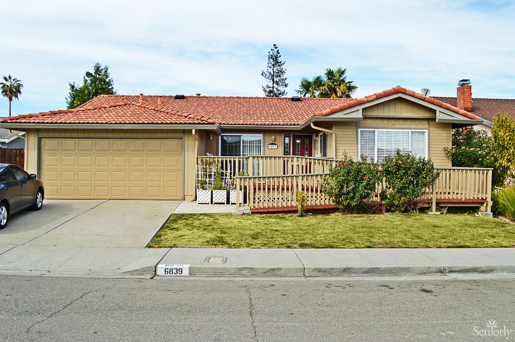 A suburban house with a two-car garage, front yard, and a small porch.
