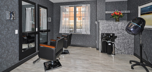 A modern hair salon with sleek chairs and natural light coming through the window.