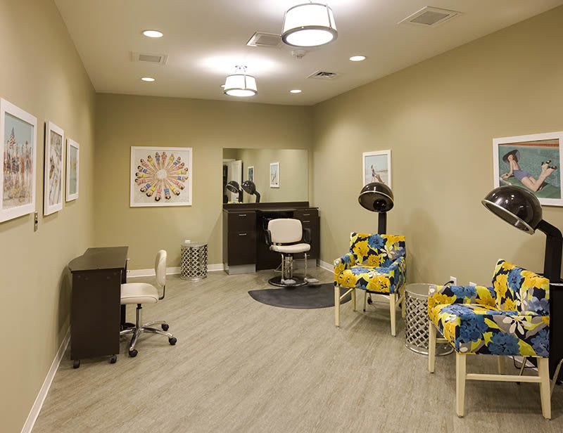 A modern salon interior with colorful chairs and hair dryers.