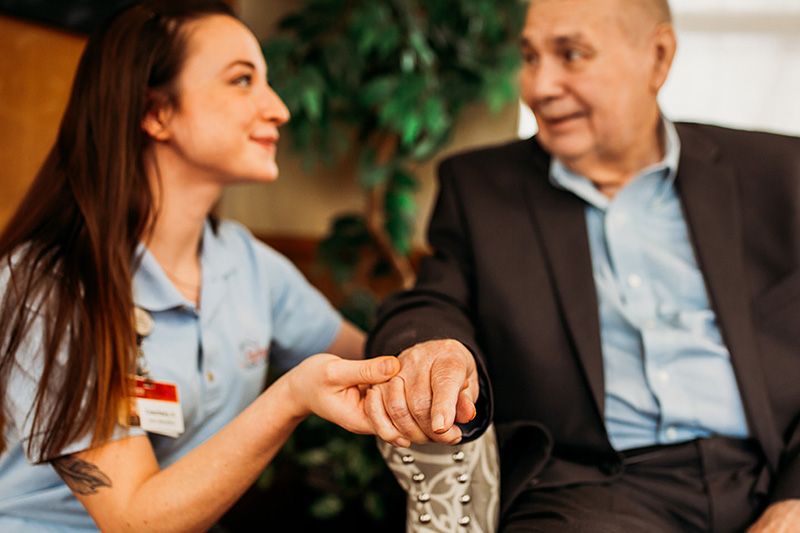 A caregiver holding hands with an elderly person, showcasing companionship and support.