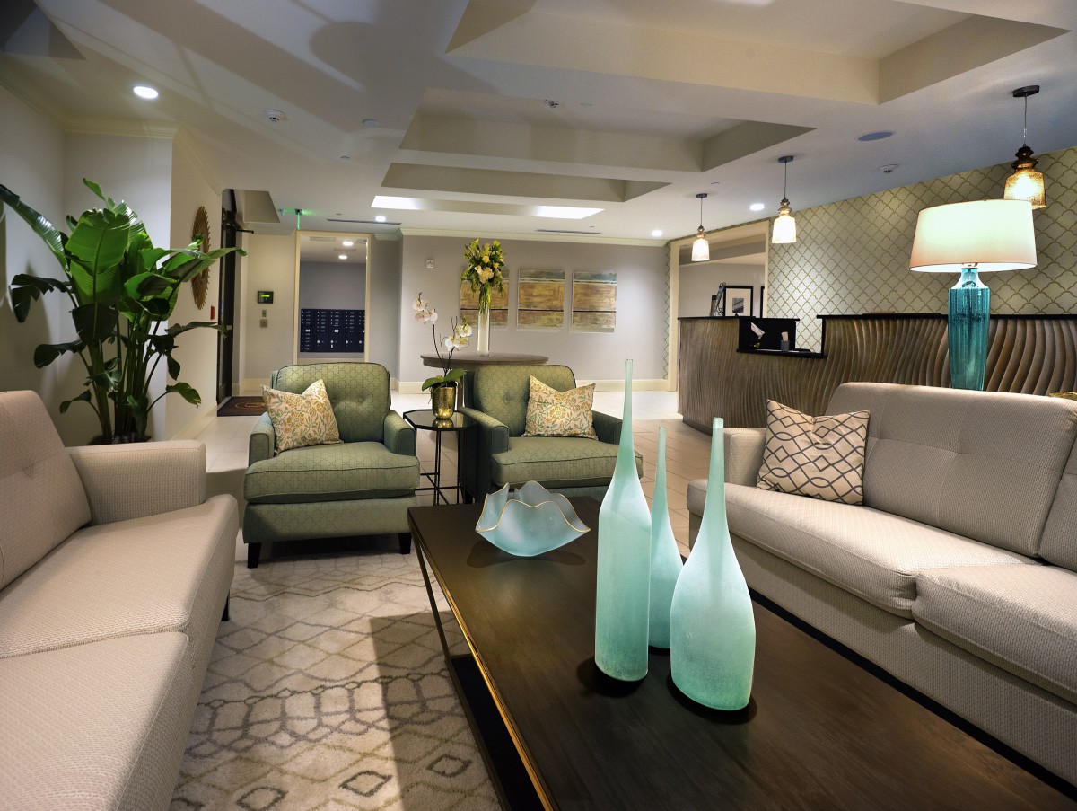 A modern living room with stylish furniture and elegant decor, featuring glass vases on a wooden coffee table.
