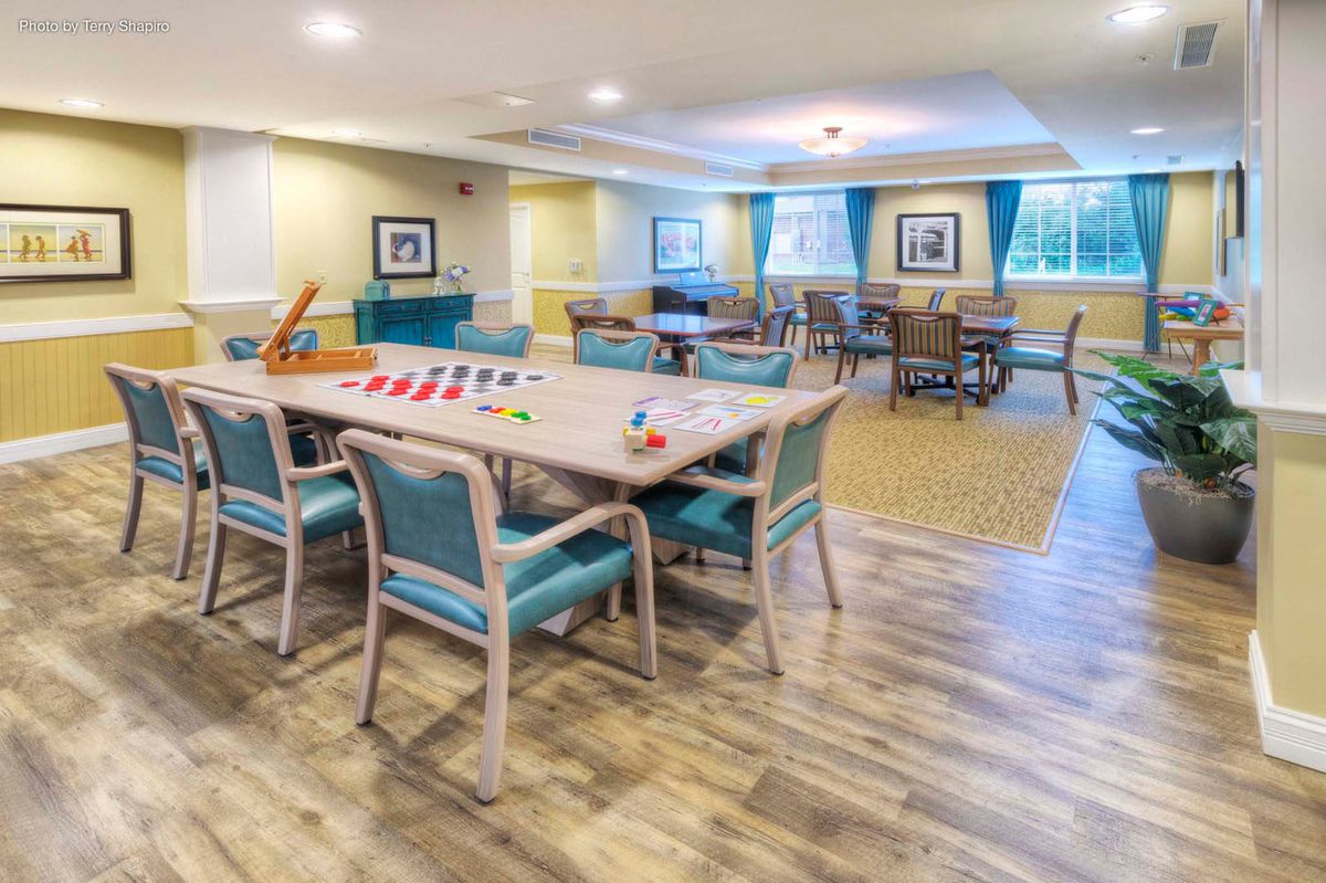 A spacious and well-lit game room with tables and chairs arranged for activities.
