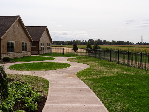 A winding pathway leads through a well-maintained yard next to a house.