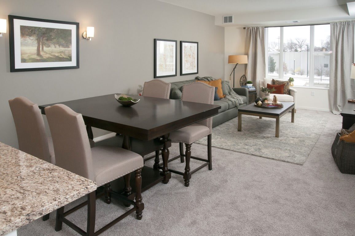 A modern living room with a dining area, featuring elegant furniture and contemporary decor.