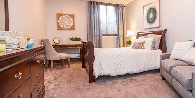 A cozy bedroom with elegant decor, featuring a comfortable bed and a wooden desk by the window.
