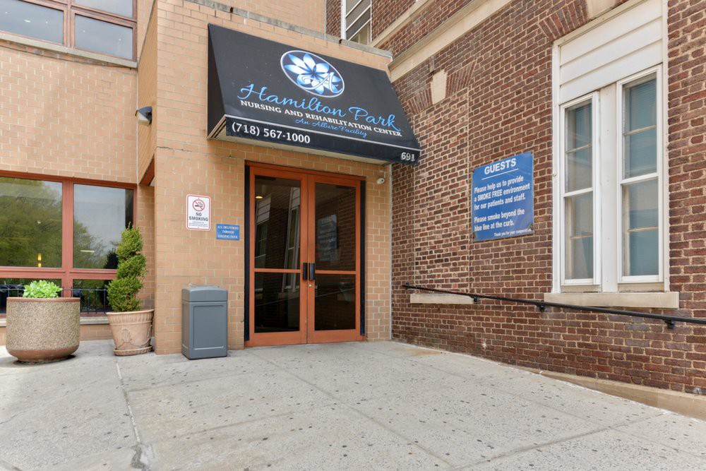 Entrance to a building with a black awning and brick exterior.