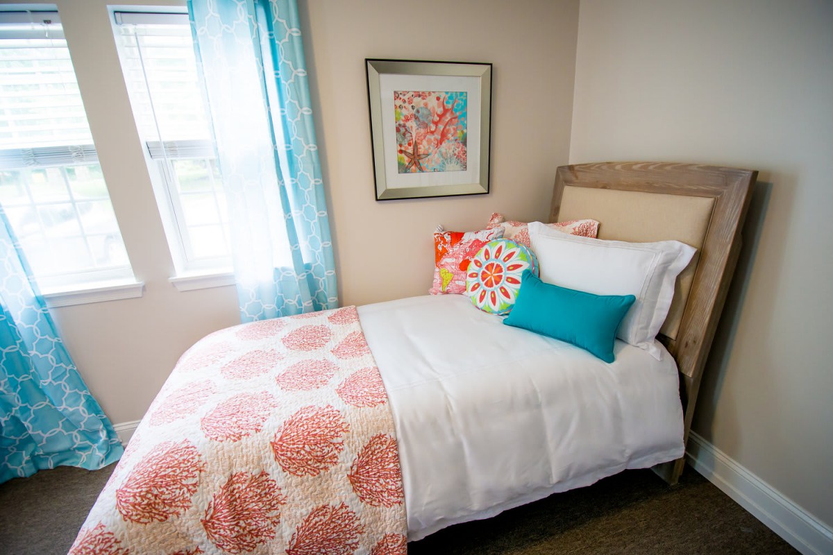 A cozy bedroom with colorful throw pillows and vibrant decor.