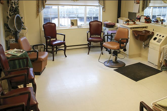 An interior view of a barber shop with seating and a barber chair.
