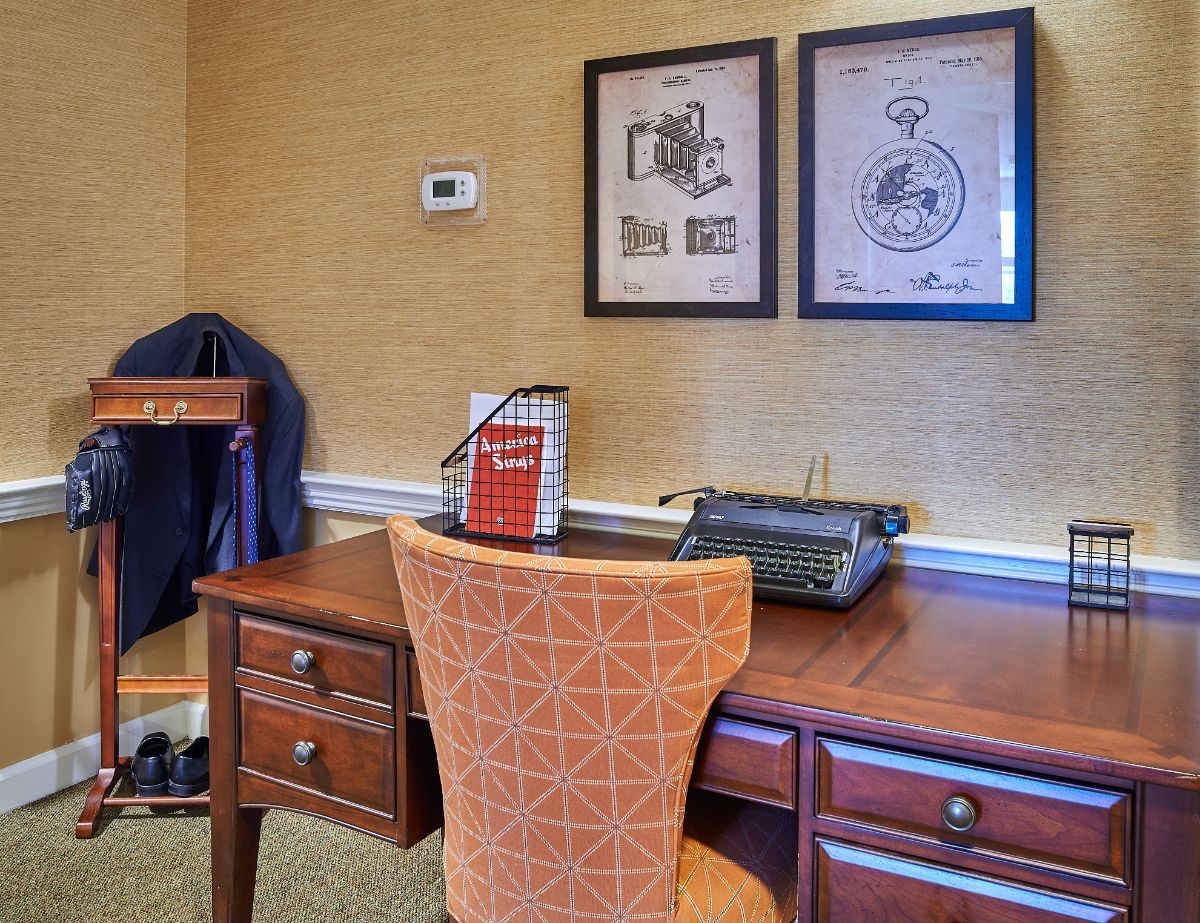 A retro-themed office space featuring a wooden desk and a vintage typewriter.