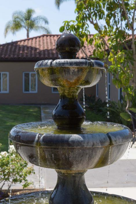 A decorative outdoor fountain with cascading water in a garden setting.