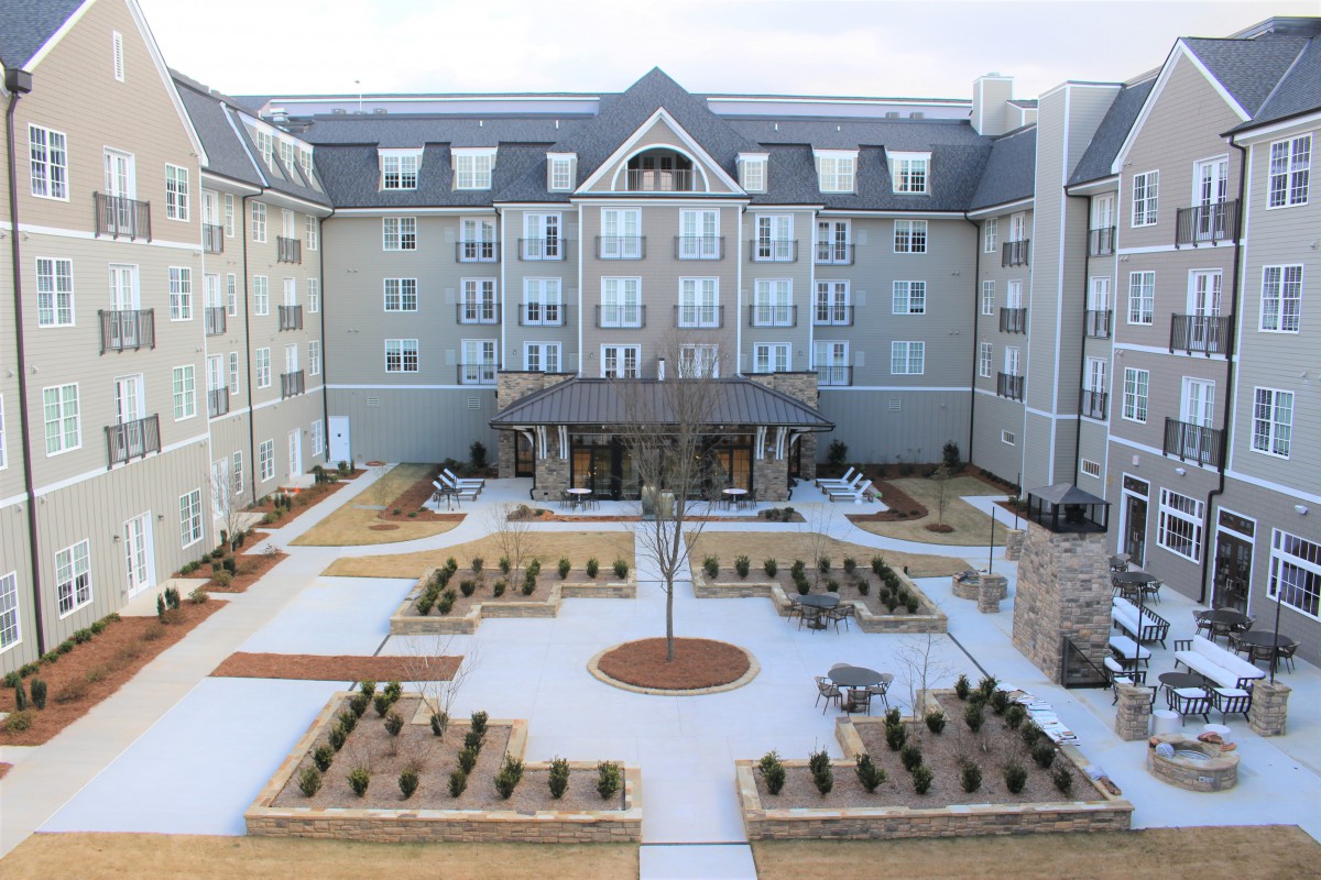 A symmetrical building with a landscaped courtyard and modern architecture.