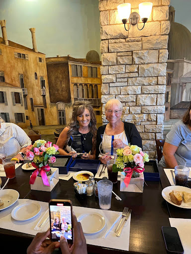 A joyful gathering of friends enjoying a meal together, surrounded by beautiful floral arrangements.