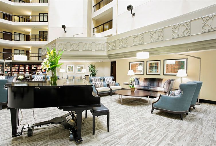 Elegant hotel lobby with a grand piano and comfortable seating.
