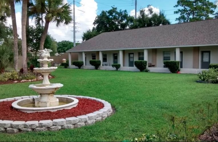 A suburban house with a well-maintained lawn and decorative fountain.
