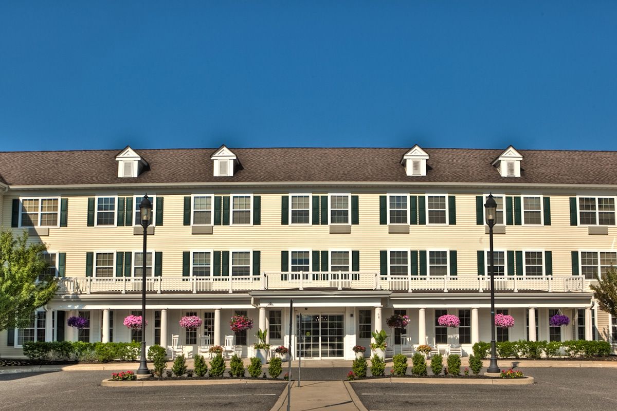 A large, traditional-style hotel building with multiple windows and a clear blue sky in the background.