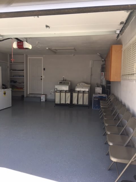 Empty garage with washing machines and chairs lined up.
