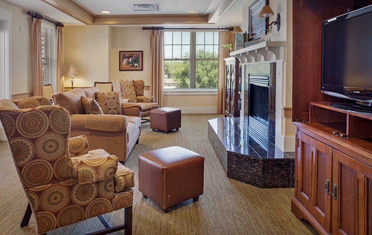 A cozy living room featuring a sofa, armchairs, and a fireplace.
