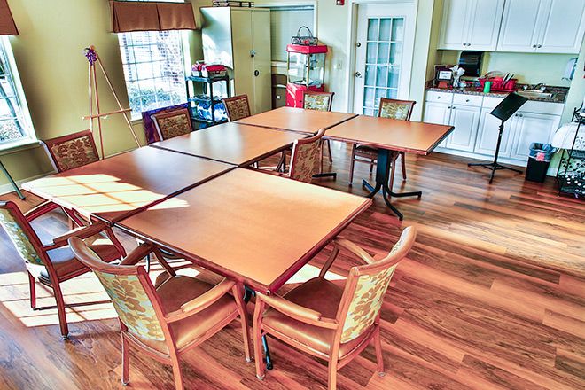 A cozy dining space with wooden tables and chairs on a hardwood floor.