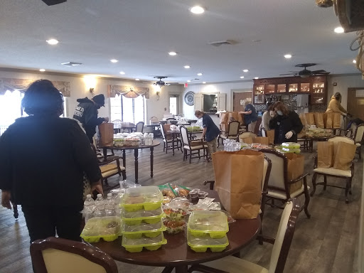 A community dining hall set up with food packages as people prepare for an event.