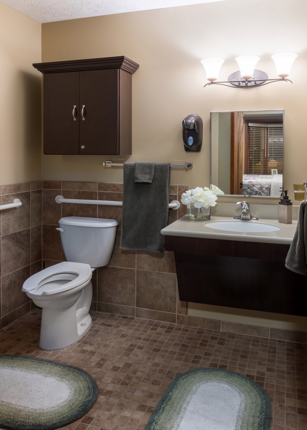 A modern bathroom with a toilet, sink, and mirror.