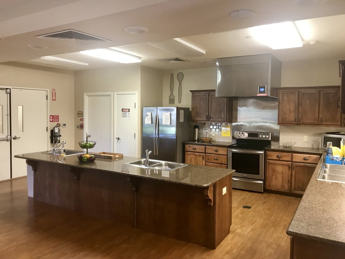 A modern kitchen with stainless steel appliances and wooden cabinets.