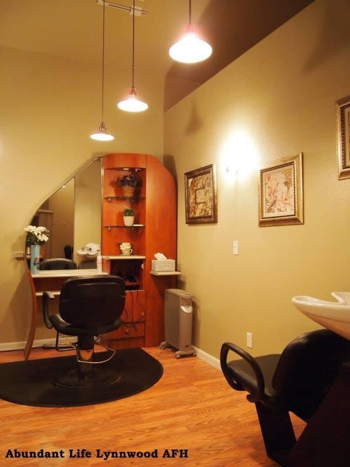 A cozy hair salon interior with a styling station and comfortable lighting.