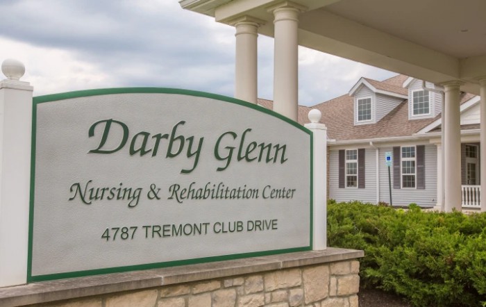 Sign for Darby Glenn Nursing & Rehabilitation Center with building in the background.