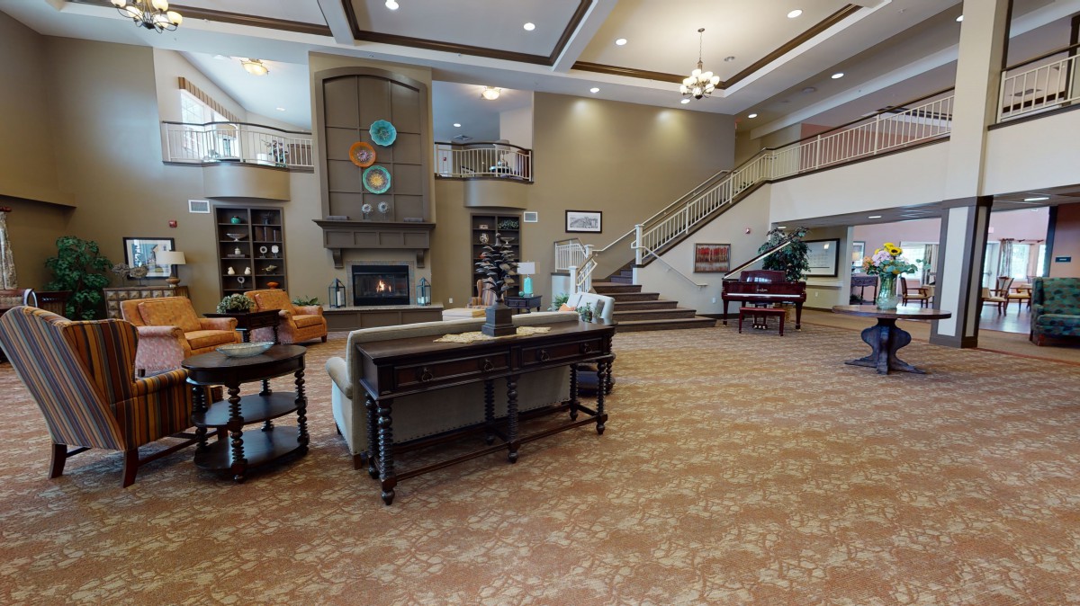 A modern lobby featuring a large staircase, comfortable seating, and a fireplace.