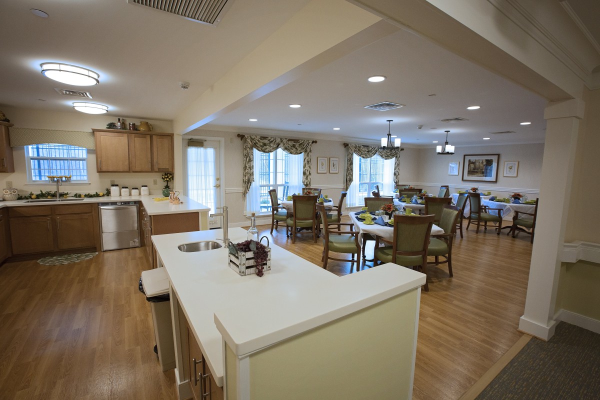 A spacious open-plan kitchen and dining area with modern furnishings and ample lighting.