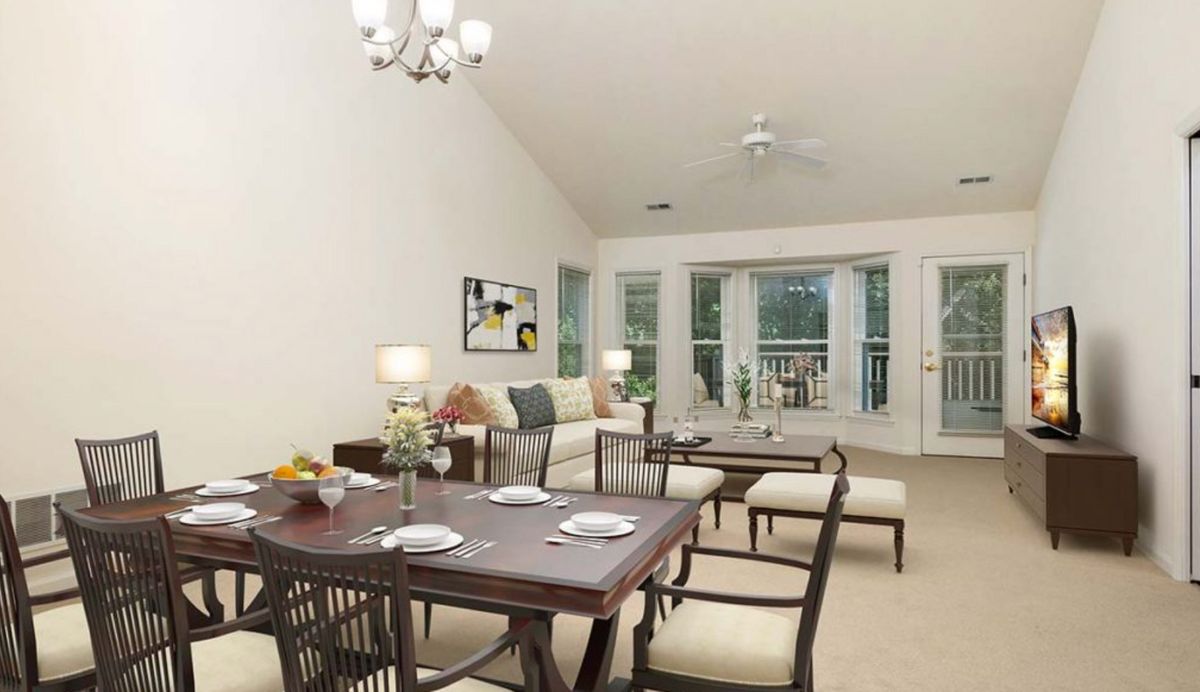 A spacious and well-lit living and dining area featuring modern furniture.
