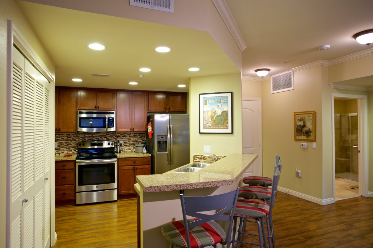 A modern kitchen with stainless steel appliances and a cozy bar seating area.