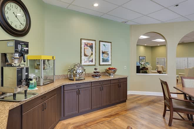 A reception area with green walls, featuring a counter with a popcorn machine and artwork on the walls.