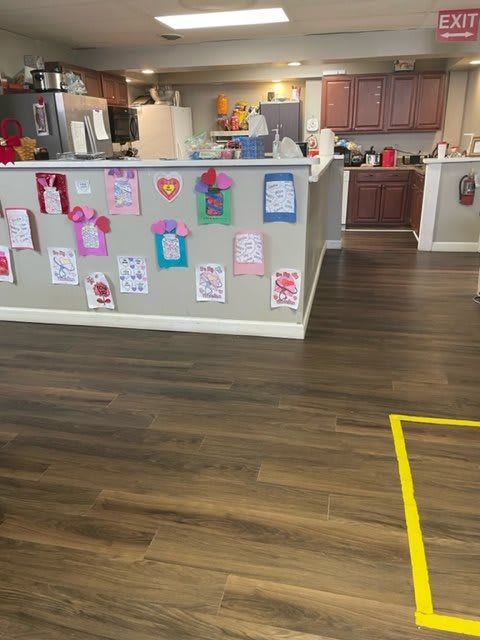 A kitchen area decorated with children's artwork displayed on the counter wall.