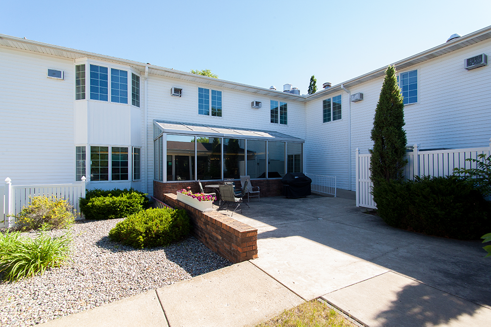 A modern house with a spacious backyard patio and sunroom.