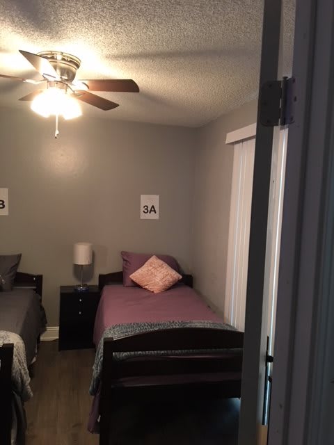 A cozy bedroom with two twin beds and a ceiling fan.