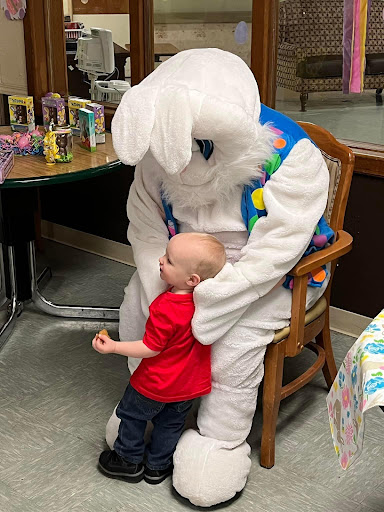 A joyful moment as a child interacts with the Easter Bunny in a festive setting.