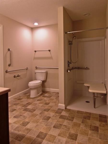 Accessible bathroom with grab bars and a walk-in shower.