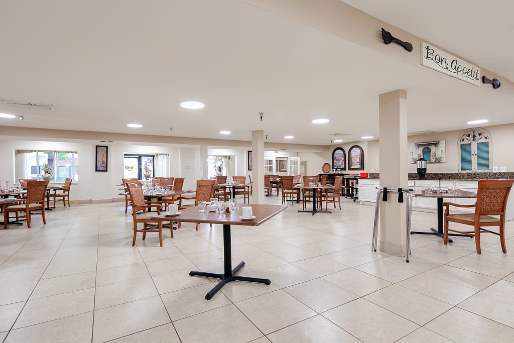 An empty dining area with neatly arranged tables and chairs in a restaurant setting.