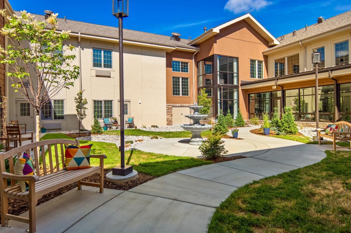 Modern building with a landscaped courtyard featuring a path and benches.