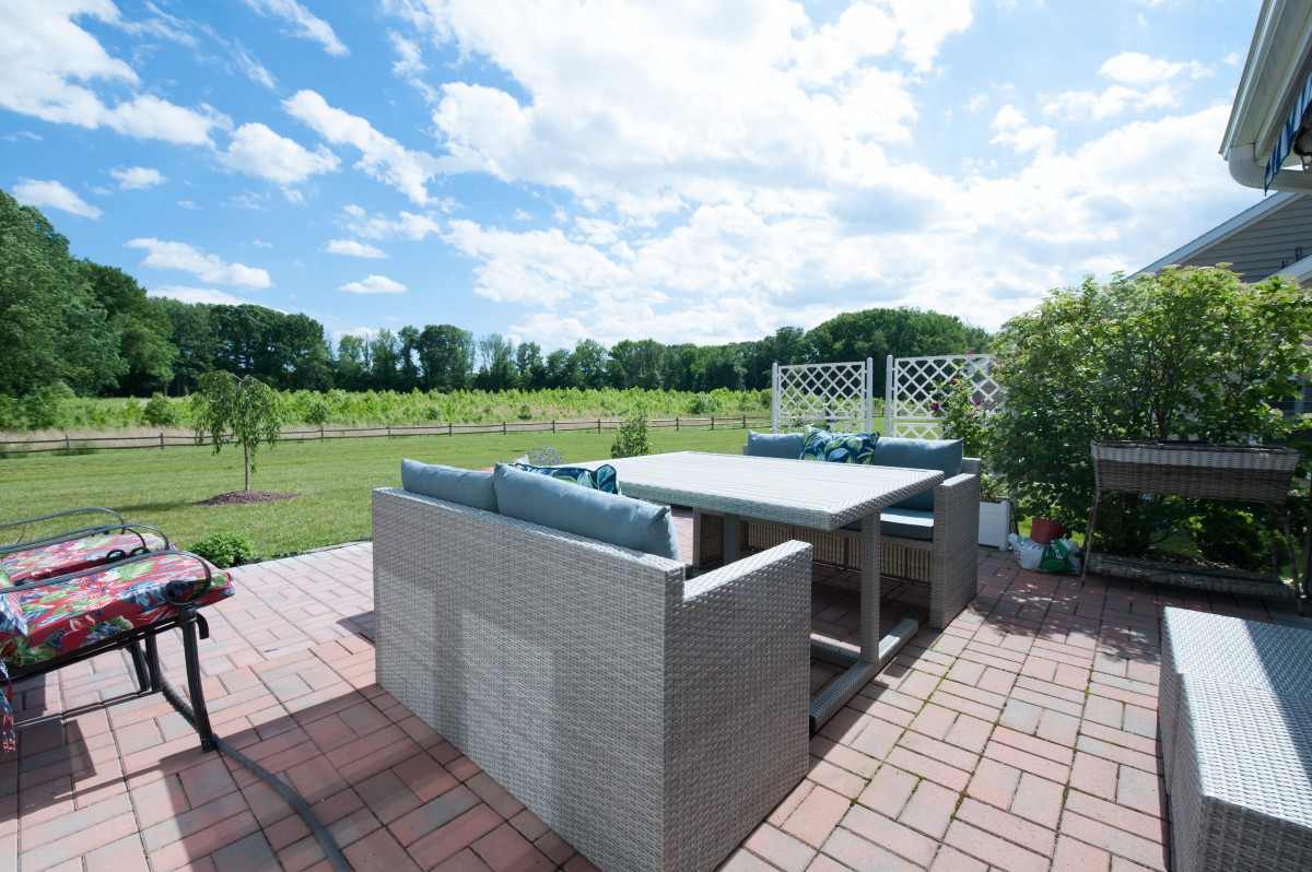 A patio set overlooking a lush green landscape under a partly cloudy sky.