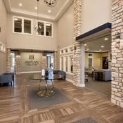 A spacious and modern lobby with wood flooring and elegant furnishings.
