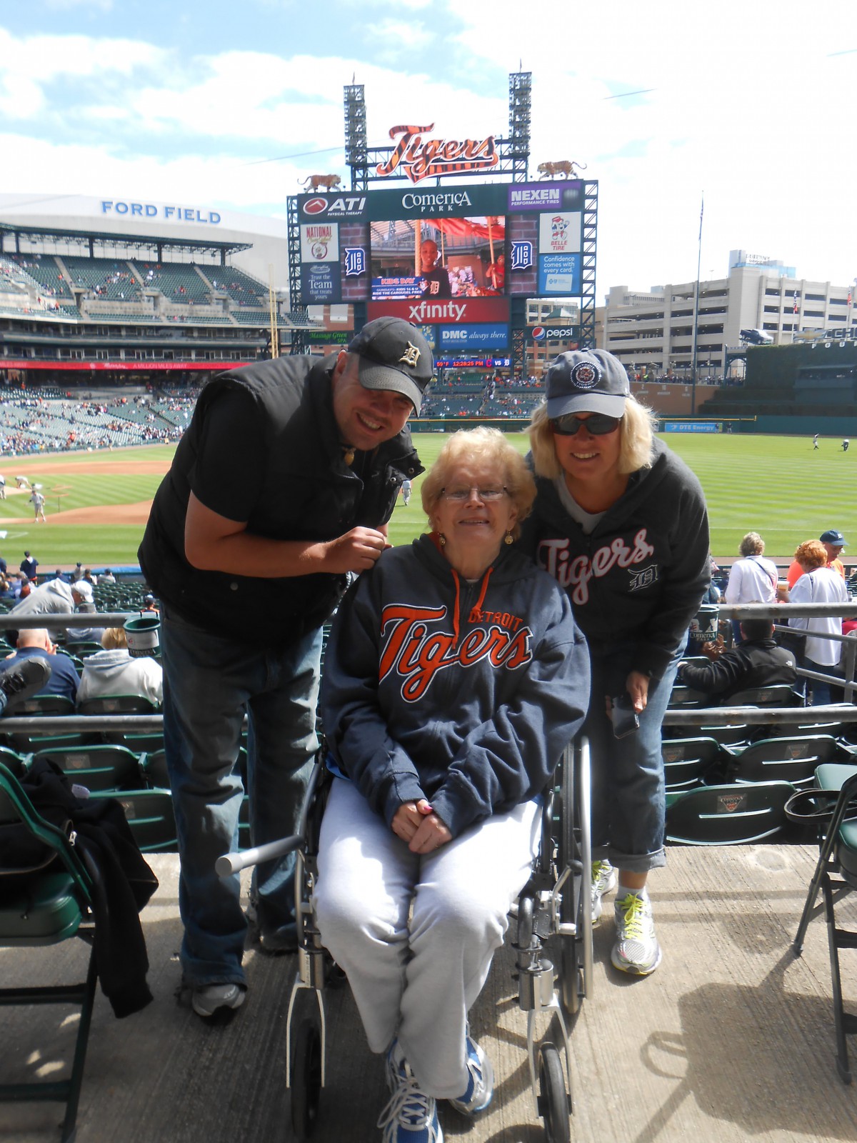 A family enjoying a day at the baseball stadium, with one member in a wheelchair.
