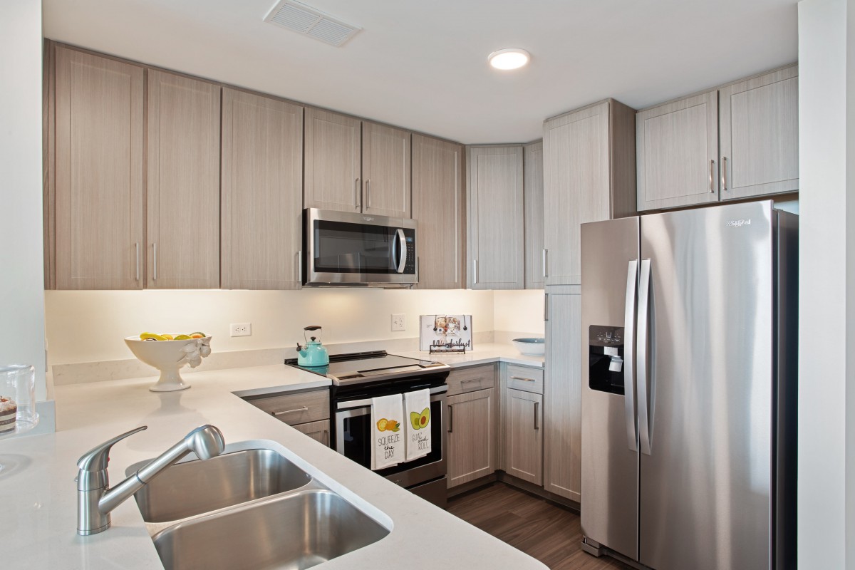 A modern kitchen with stainless steel appliances and wooden cabinets.
