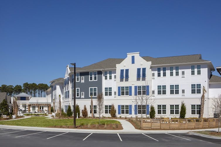 A modern residential building with a clear blue sky in the background.