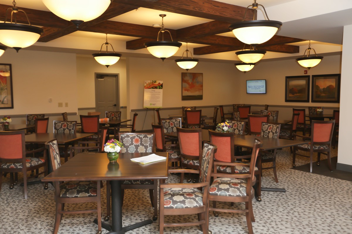 A cozy dining room with wooden furniture and warm lighting.