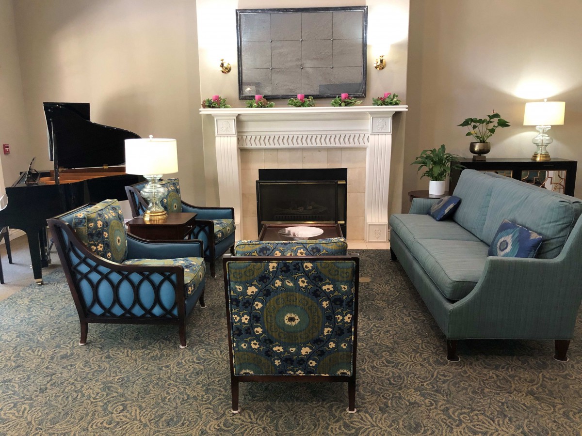 A cozy living room with a fireplace, surrounded by comfortable seating and elegant decor.