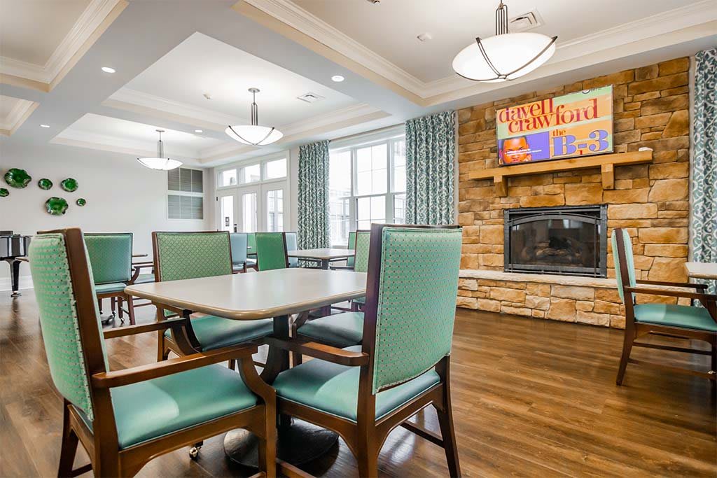 A cozy dining area featuring a fireplace, modern lighting, and comfortable seating.