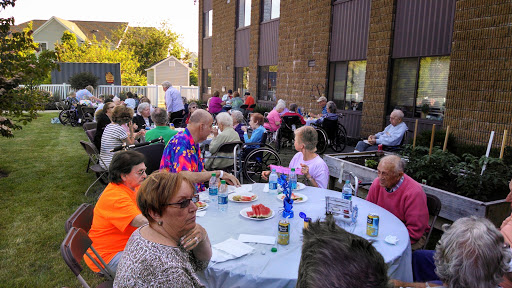 A lively outdoor community gathering with seniors enjoying food and conversation.