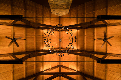 A stunning view of an intricately designed wooden ceiling, illuminated by warm lighting.