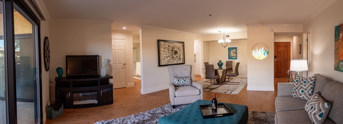 A stylishly decorated living and dining area with elegant furnishings and artwork on the walls.